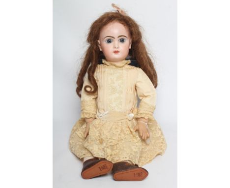 A Tete Jumeau bisque socket head doll, with blue glass fixed eyes, closed mouth, pierce ears, brown wig, wood and composition