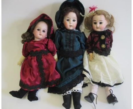 Three bisque head dolls, comprising a 10 1/2" Schoenau & Hoffmeister 4000 8/0 socket head, with brown glass fixed eyes, teeth