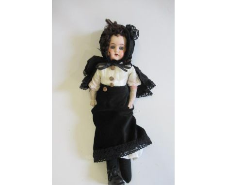 A Cuno & Otto Dressel bisque shoulder head doll, with blue glass fixed eyes, open mouth, teeth, cloth body and composition lo