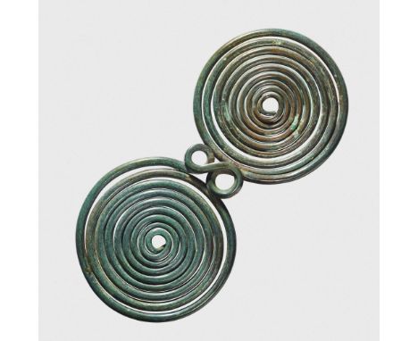  LARGE BRONZE AGE SPIRAL PENDANT CENTRAL EUROPE, C. 900 - 700 B.C. bronze wire, the "spectacle type" fibula formed of two opp