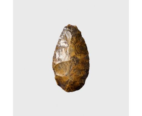  FLINT HANDAXE PALEOLITHIC PERIOD, THEBES, EGYPT, C. 300,000 – 100,000 B.C. knapped flint, of teardrop form, dark caramel col