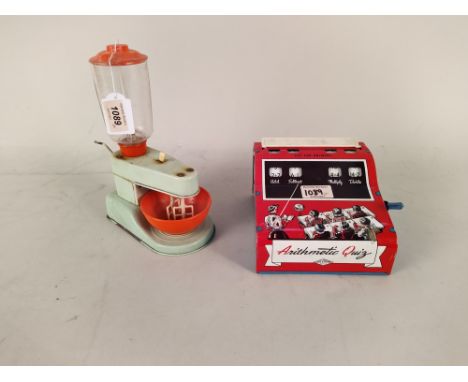 A vintage tin plate 'Wolverine' Arithmetic Quiz machine together with a 'Patent Gama Mechanic' tin plate toy blender