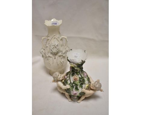 A late Victorian Sitzendorf porcelain vase decorated with two cherubs and rose bush, One cherub having damage. Parian ware va