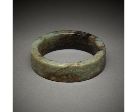 Chinese carved jade bangle. The sides carved with horses. Of a dark green jade with mottled black and russet inclusions.Exter