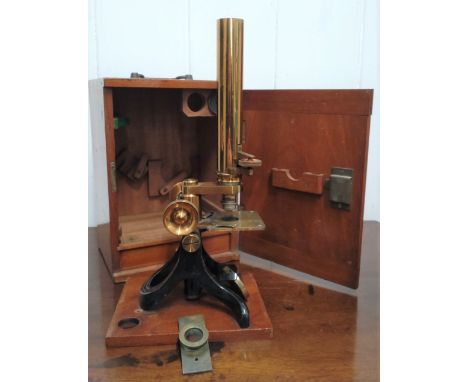 A brass microscope by Lawrence & Mayo.  London & Calcutta with accessories in original wood cabinet, with key. The Optical an