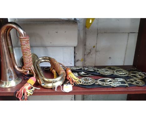 A brass Royal Welsh Fusiliers bugle (lacks mouthpiece), a copper and brass bugle and eleven horse brasses on three leather on