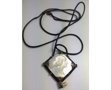 A mother of pearl pendant showing the face of a 1920's lady. 