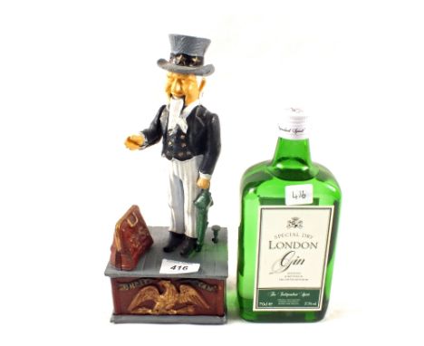 A reproduction Uncle Sam mechanical money box and a bottle of London Gin