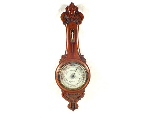 A carved Oak aneroid barometer