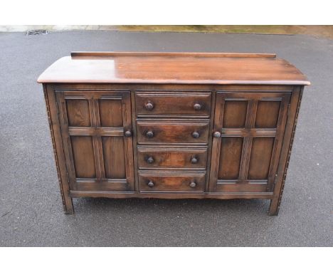 Ercol dark elm sideboard with 2 doors and 4 drawers. In good functional condition with some areas of damage to one foot and g