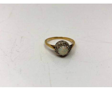 An 18ct gold and platinum opal and diamond cluster ring, size O.  CONDITION REPORT: 3.3g