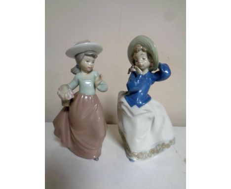 Two Nao figures, girl with basket and girl with bird on shoulder 