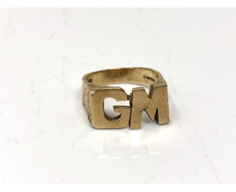 A 9ct gold ring with initials GM, size V.  CONDITION REPORT: 9.4g