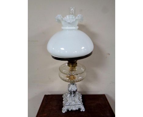 A 19th century cast iron based oil lamp with glass reservoir (as found), chimney and shade  