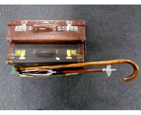 A box containing a vintage luggage case together with a further vintage style luggage case, a walking stick and a shooting st