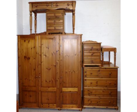 A modern pine bedroom suite comprising triple wardrobe, 4 height chest of drawers, dressing table and stool, and a pair of be