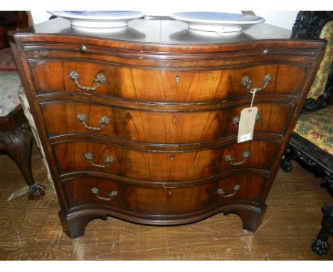 An early George III style walnut serpentine commode, cross-banded and ebony line inlaid fitted brushing slide above four grad