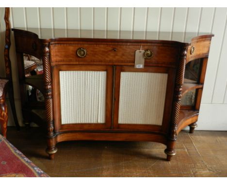 A Regency concave fronted side board, fitted with a central frieze drawer with compartmentalised interior, having a baize lin