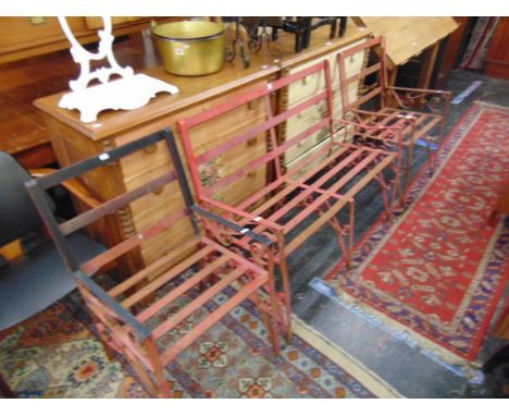 A metal garden bench and two matching chairs