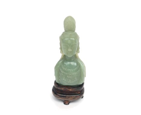 A jade bust on wooden stand, height 13cm, width 6cm.