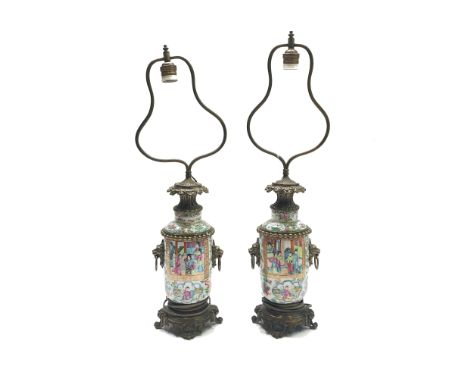 A pair of Chinese Canton porcelain lamp vases, late 19th century, painted in a typical palette with panels of figures within 