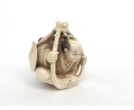A Japanese ivory netsuke of a seated man, circa 1900, signed, height 4.5cm, width 4cm.