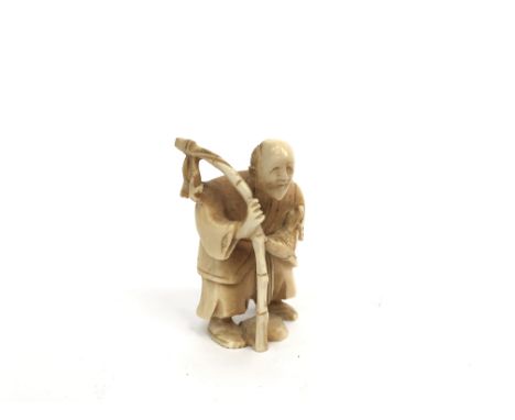 A Chinese carved ivory netsuke, an elderly gentleman carrying a bamboo cane with fish, incised signature to base, height 5.5c