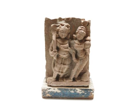 A South East Asian carved stone relief panel, 19th century, depicting two standing figures, on a later wooden base, height 33