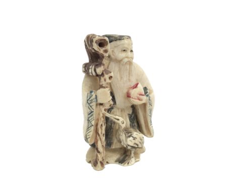A Chinese part coloured carved ivory netsuke, an elderly gentleman wearing a robe, carrying a fruit and holding a staff and w