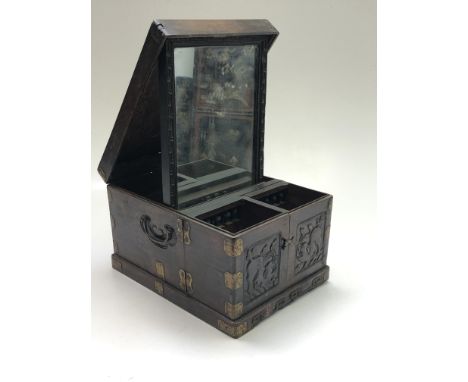 A Korean hardwood brass bound vanity case, 19th century, the hinged lid opening to reveal a rectangular mirror above an assor