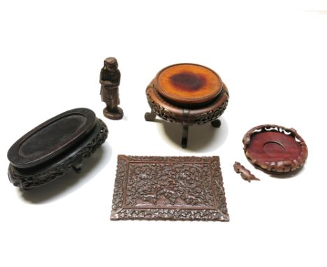 Three Chinese carved hardwood stands, an Indian carved panel, 14.5 x 20cm and a carved wood figure, height 14cm.