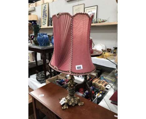 An ornate brass table lamp with decorative shade