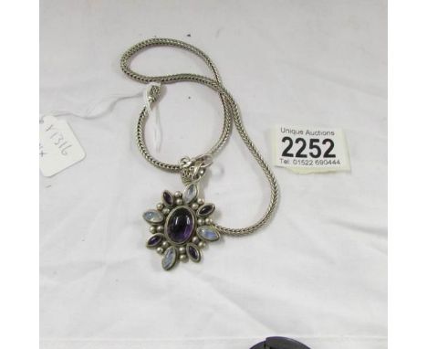 An amethyst and gem set pendant on silver chain.