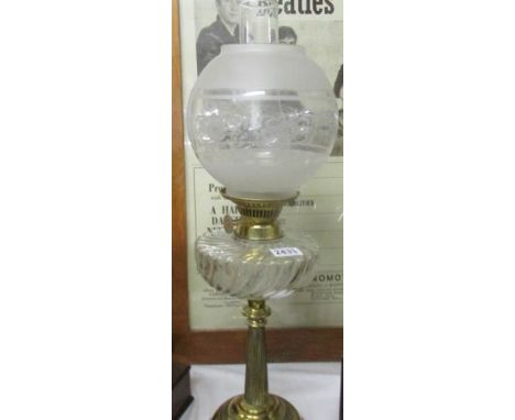 A brass oil lamp with brass font and complete with shade and chimney.