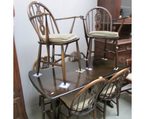 An Ercol style dining table and 6 chairs.