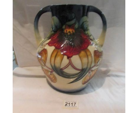 A large twin handled Moorcroft Anna Lily vase, approximate height 10.25", (label indicates that it is second quality).