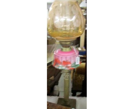 A Victorian brass Corinthian column oil lamp with pink glass font complete with shade and chimney,