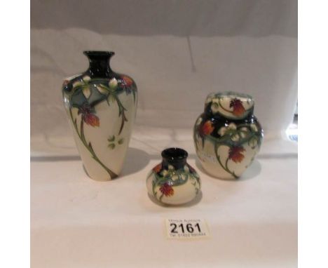 A matching set of 3 Moorcroft items being a vase, a lidded pot and a miniature squat vase.