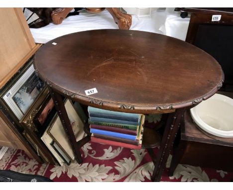 An oval carved side table with under gallery