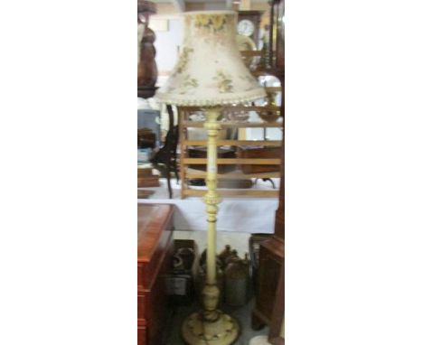 A painted standard lamp with shade.