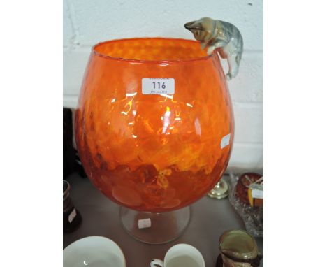 A large vintage over sized brandy glass with orange colour