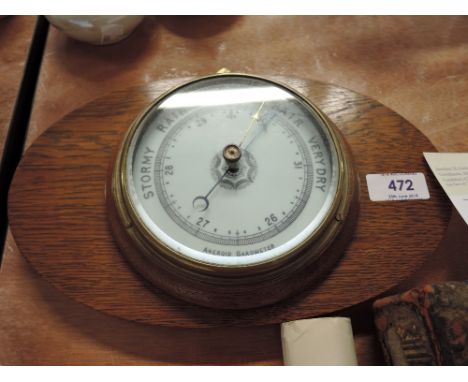 A vintage wall mounted barometer with oak body