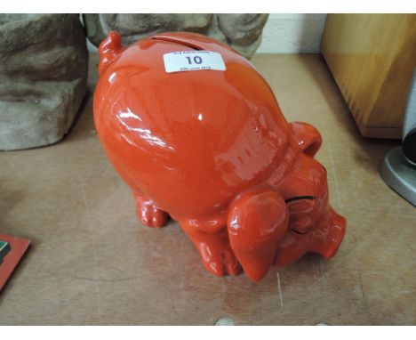 A oriental style ceramic piggy bank with red glaze