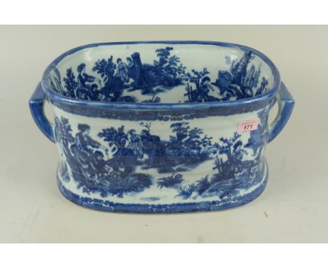 A blue and white ceramic foot bath, transfer printed with scenes of people fishing and in landscapes