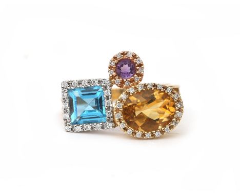 A 14 karat gold diamond, amethyst, citrine and topaz ring. Featuring an asymmetrical cluster design with coloured gemstones i