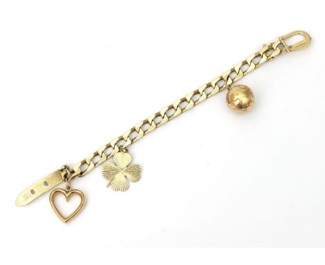 A 14 karat gold charm bracelet. Twisted link bracelet with three charms; a globe, a four-leaf clover and a heart to a pin buc