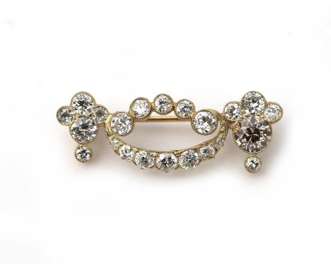 A 14 karat gold diamond festoon brooch. Featuring brilliant and old mine cut diamonds, amongst cognac coloured tinted, ca. 1.