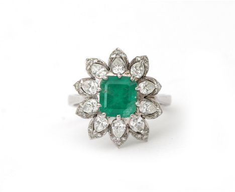 A diamond and emerald cocktail ring. A cluster design featuring an emerald of ca. 2.08 ct. in a diamond surround. Gross weigh