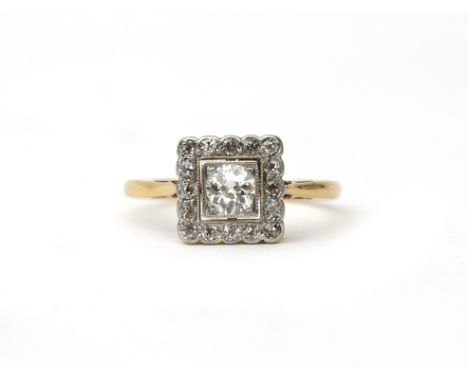 An 18 karat gold and platinum Art Deco diamond cluster ring. Featuring an old brilliant cut diamond of ca. 0.20 ct. in a surr