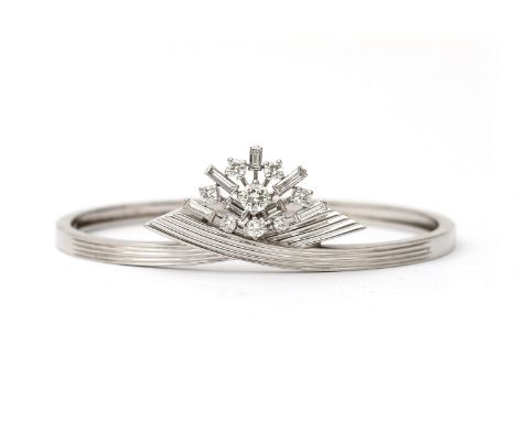 A 14 karat white gold diamond bangle, by Rozendaal. A stiff bangle with a diamond set frontal part. Central diamond is ca. 0.